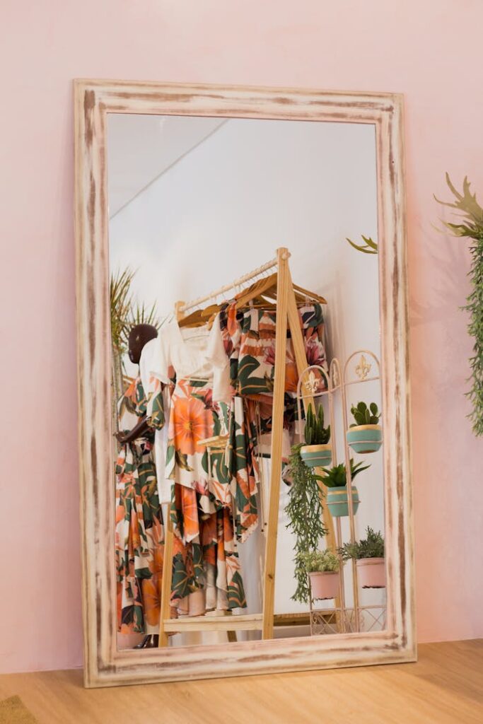 Stylish floral dresses reflected in a boutique mirror with indoor plants.